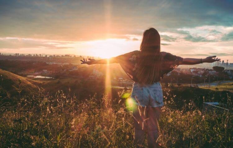 Woman standing in a field with her arms out