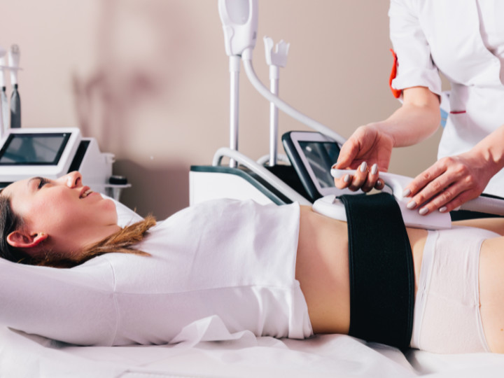 emsculpt machine being used on woman's abdomen