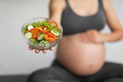 pregnant women holding salad