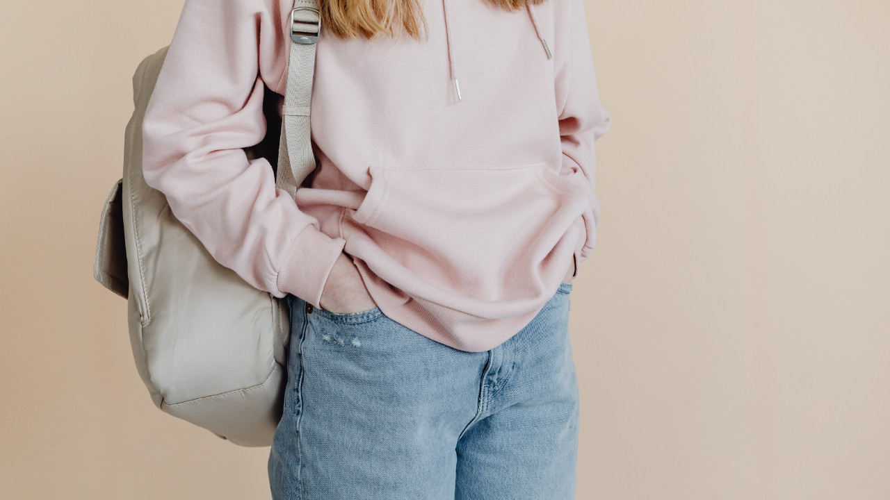 a girl with a backpack on one shoulder 