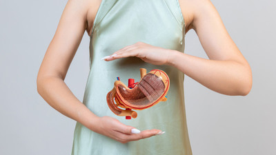 Woman holding her stomach and taking bariatric surgery recovery supplements from Bella Medical Associates to support healing, nutrition, and long-term weight loss success.