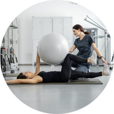 A woman working out with a personal trainer in a gym.