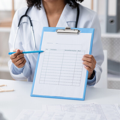 Medical provider holding a clipboard offering qualifying medical cannabis evaluations in North Carolina and Washington State at Bella Medical Associates.