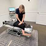 Chiropractor performing thoracic adjustment