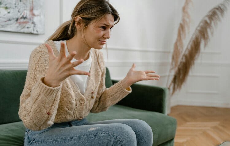 Woman sitting on a couch looking upset