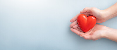women holding red heart with blue background