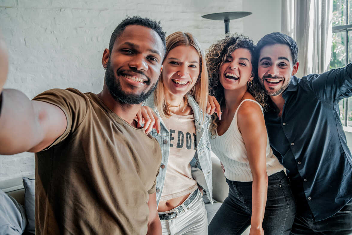 A friend group of four is smiling for a photo