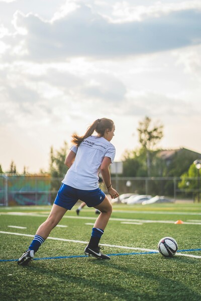 Female youth athlete playing soccer after return-to-sport physical therapy
