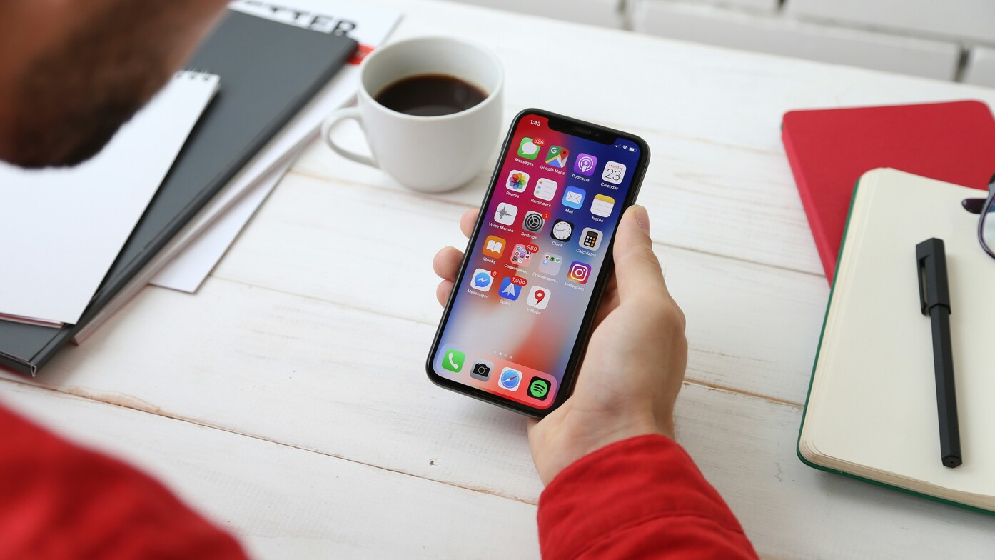 Person holding mobile phone with apps representing apps to help with new years resolutions