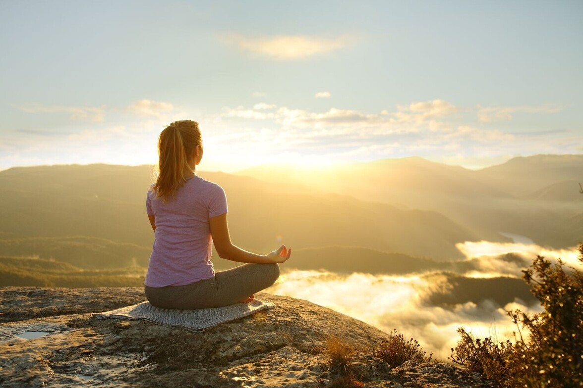 person meditating on mountain