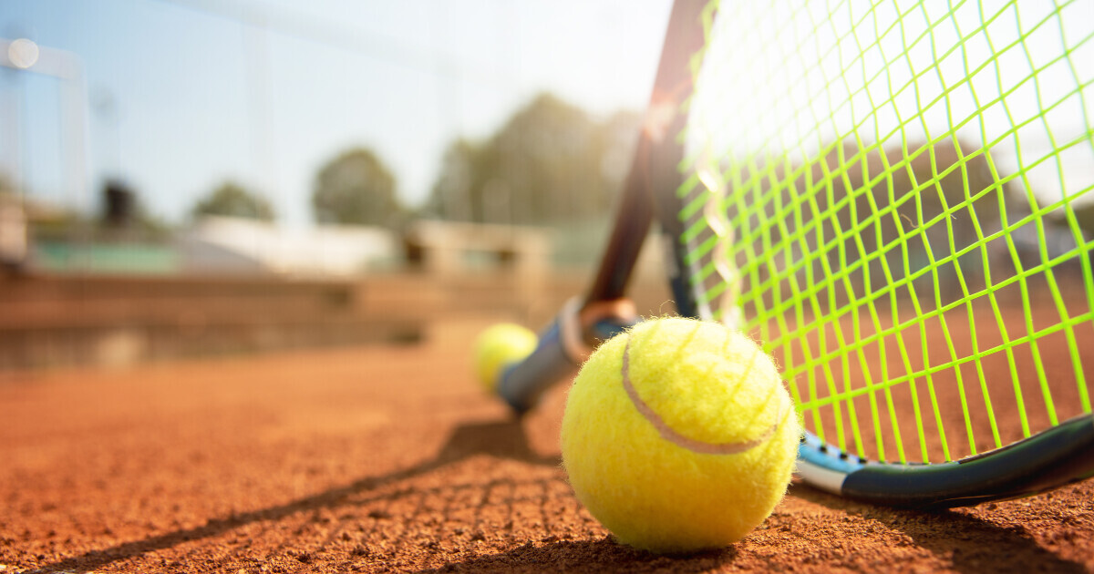 a photo of a tennis racquet and tennis ball on a court 