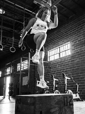 Patient working with a provider at a CrossFit and performance physical therapy clinic in Dallas, TX during a return-to-sport exercise progressio