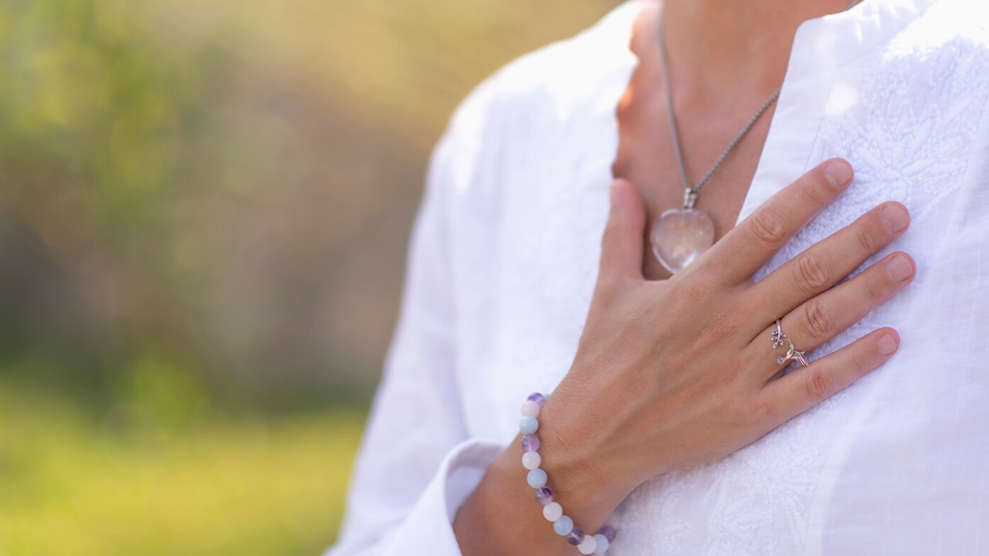 Mindfulness and depth-oriented therapy concept — woman touching heart as a gesture of presence and healing.