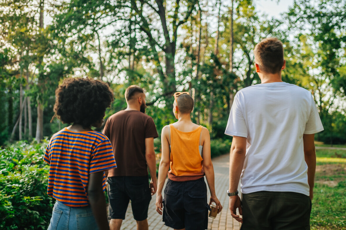Rear view of multicultural friends walking in nature and exploring