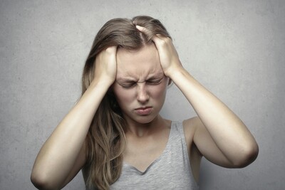 Woman holding her head due to dizziness