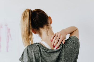 Girl rubbing her sore neck. 
