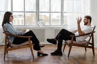 Man sitting in front of woman who is giving him advice. 