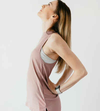 athletic woman holding her back in pain