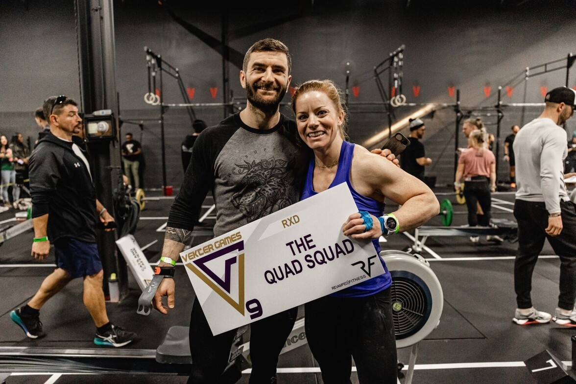 Teammates holding their team sign and smiling.