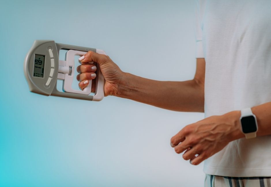 man using grip strength measuring tool