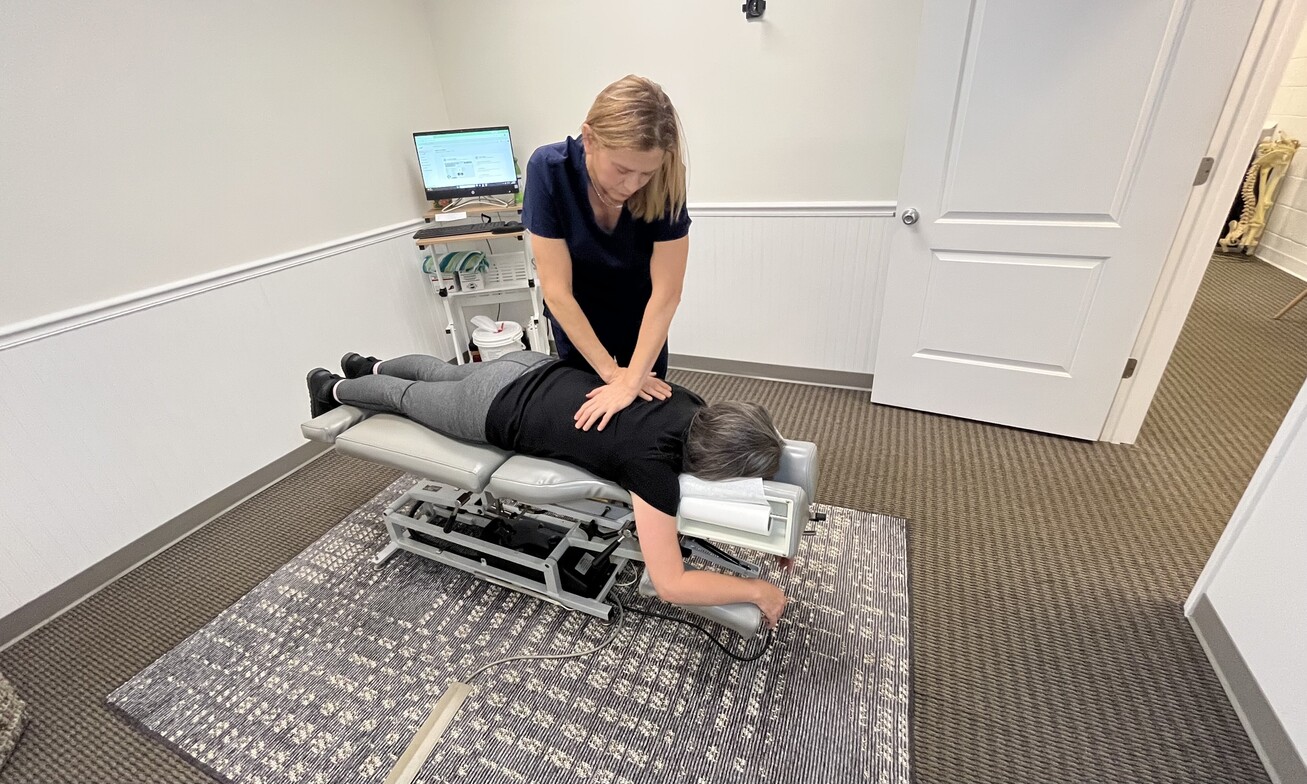 Chiropractor performing thoracic adjustment