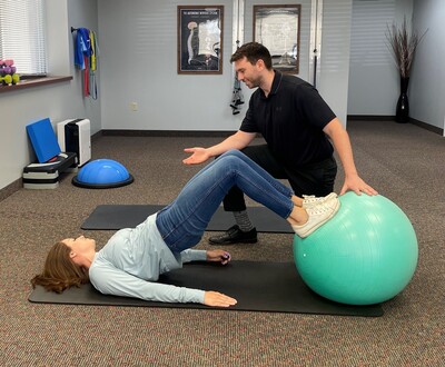 Patient performing a guided rehabilitation exercise with a stability ball