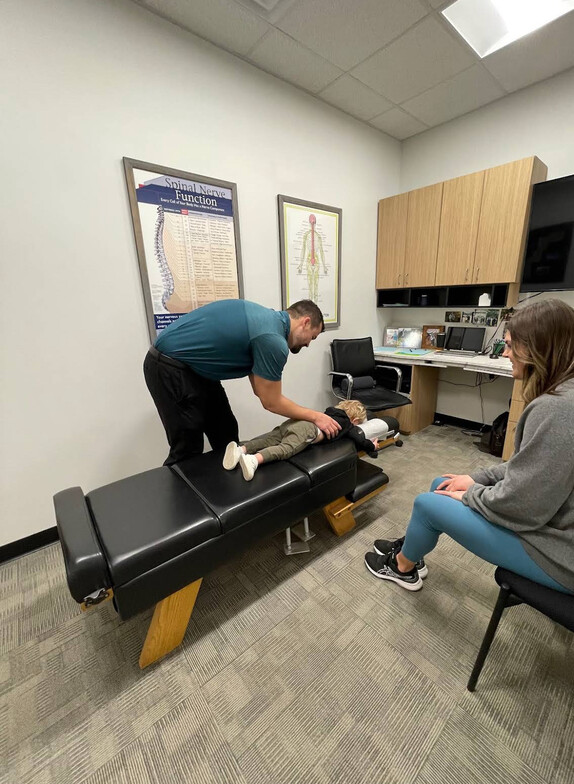 Young Waukee boy receiving gentle pediatric chiropractic adjustment at Core Chiropractic for spinal health