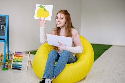Speech-language pathologist holding a lemon flashcard during an articulation therapy session.