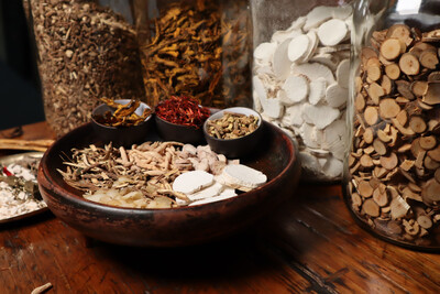 Clinical herbal medicine preparations and dried roots in apothecary jars for custom formulations.