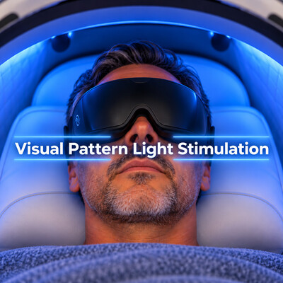 Man resting inside the Theta Chamber wearing black light-therapy goggles during a relaxation session.